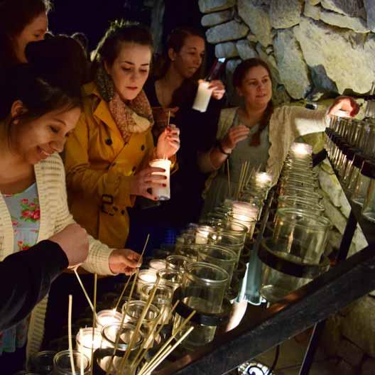 Students lighting candles at Mary's Grotto
